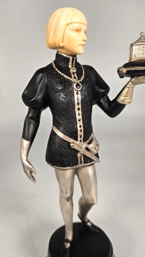 fig 1. A pair of Art Deco chryselephantine statuettes depicting medieval page boys in silvered and dark bronze with carved ivory heads on green marble bases.