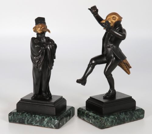 fig 1. A pair of patinated and parcel-gilt bronze figures depicting anthropomorphic birds in nineteenth-century attire mounted on green marble bases.
