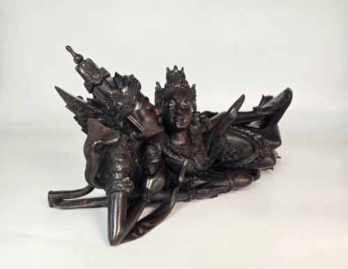 fig 1. A dark hardwood Balinese carving depicting the reclining figures of Rama and Sita with detailed ornate headdresses and traditional attire.