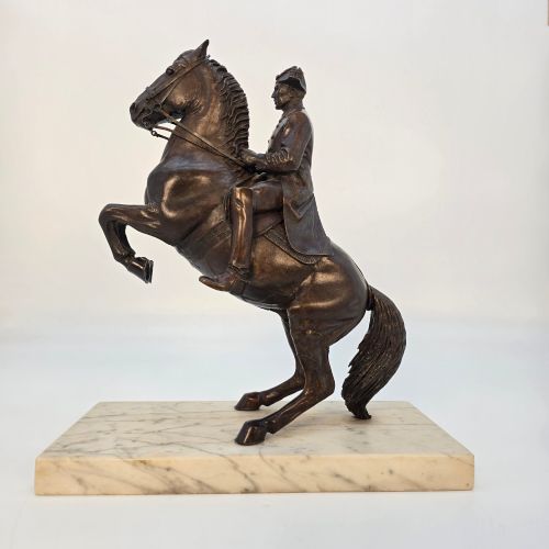 fig 2. A dark bronze equestrian sculpture depicting a uniformed rider atop a rearing horse, mounted on a rectangular cream marble plinth.