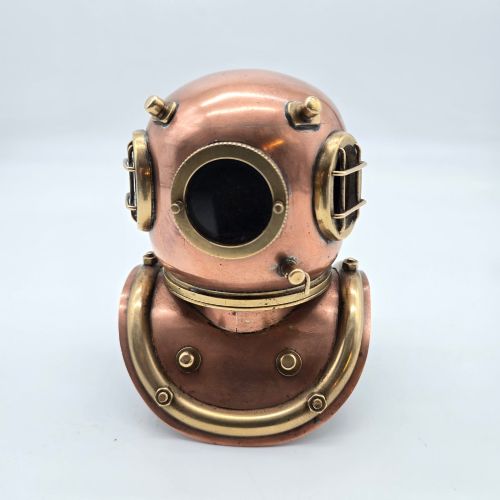 fig 1. A miniature copper and brass deep-sea divers helmet featuring glass viewports, side valves, and brass shoulder plate studs on a plain white background.