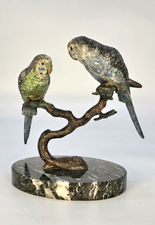 fig 1. A cold-painted bronze sculpture featuring two budgerigars perched on a branch mounted upon a round green marble base.