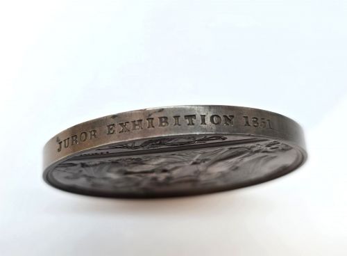 fig 2. A circular dark bronze Victorian medal displaying jugate profile portraits of Queen Victoria and Prince Albert surrounded by Latin text.