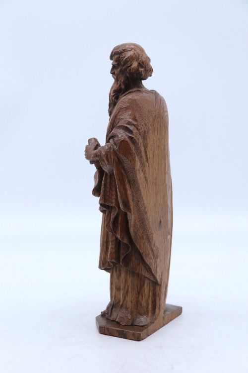 fig 1. A carved oak wooden statue depicting Saint Paul holding a sword and scroll, standing on an octagonal wooden base.