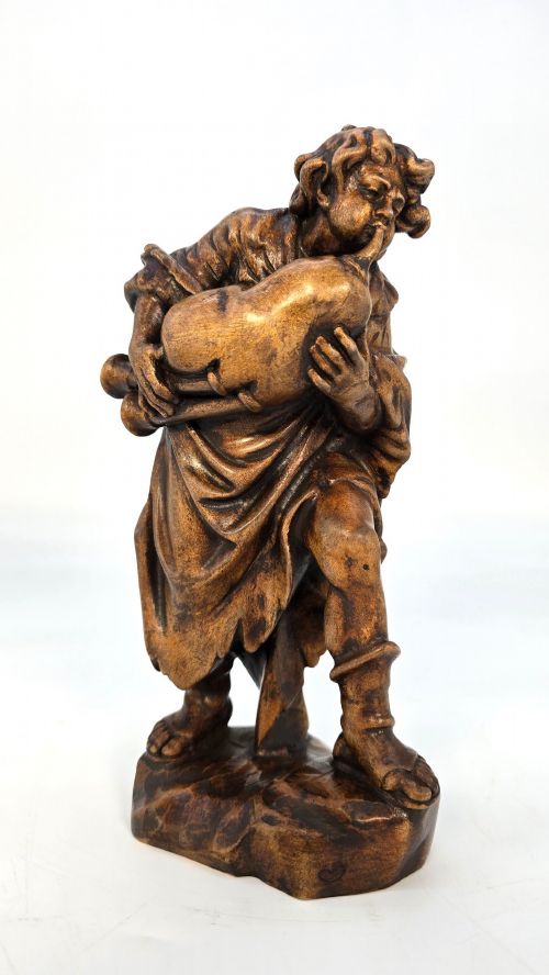 A BLACK FOREST LIMEWOOD CARVED FIGURE OF A MEDIEVAL YOUNG MAN PLAYING SWISS BAGPIPES