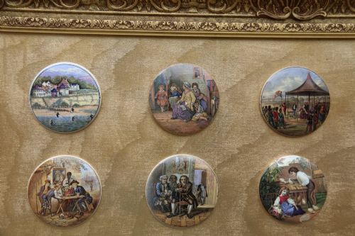 fig 1. A large rectangular ornate gilt frame displaying thirty-five circular Victorian polychrome transfer-printed ceramic pot lids mounted in grid formation.