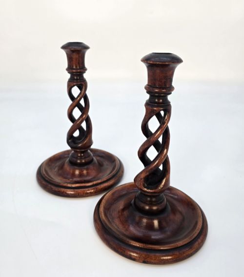 fig 1. A pair of 18th-century carved fruitwood candlesticks featuring open twist stems and wide circular bases.