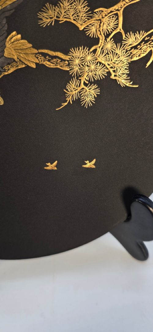 A circular black patinated iron plaque featuring an inlaid gold and silver depiction of an eagle perched on a pine branch. View VIII