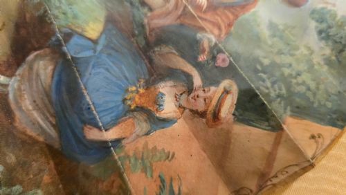 fig 4. A late 18th-century Italian folding fan featuring a hand-painted pastoral scene mounted on carved mother-of-pearl sticks, presented inside a fan-shaped black frame with a cream silk lining.