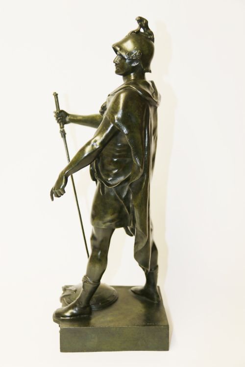 fig 1. A late 19th-century patinated dark bronze sculpture depicting a Roman warrior with a sword resting against a shield on a rectangular base.