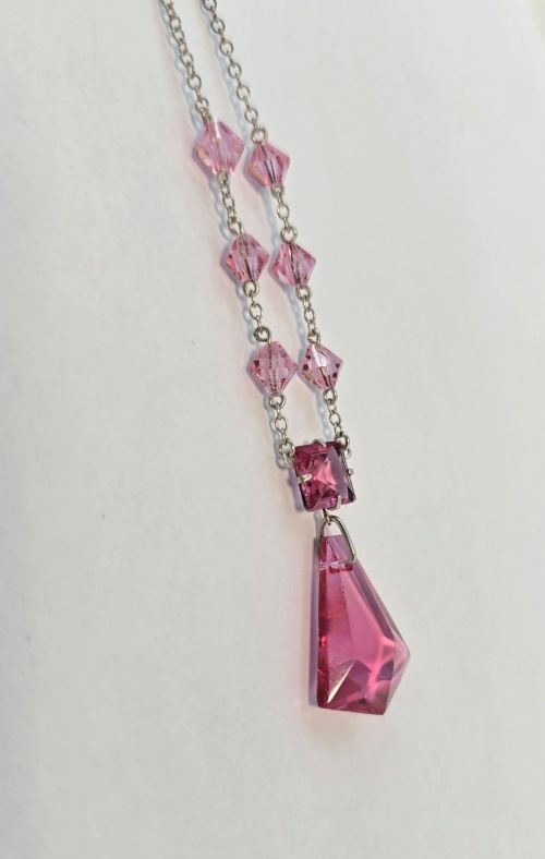 fig 2. An Art Deco style silver chain necklace featuring faceted pink crystal bicone beads and a geometric triangular crystal pendant drop.