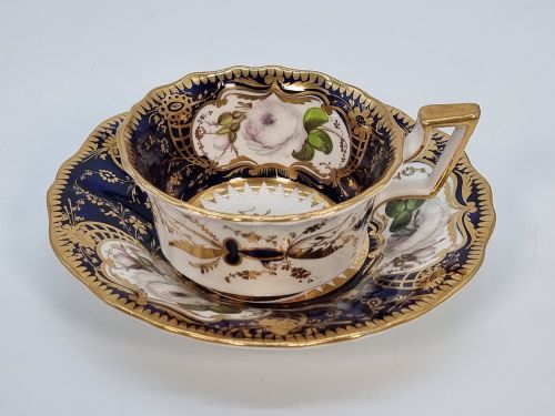 fig 1. An early nineteenth-century porcelain cabinet trio comprising a teacup, coffee cup, and scalloped saucer decorated with cobalt blue panels, gilt gilding, and hand-painted white rose reserves.