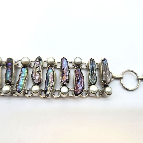 fig 1. A 1960s Japanese silver jewellery set featuring an articulated link bracelet and a matching ring set with elongated, iridescent Biwa pearls and round white pearls.