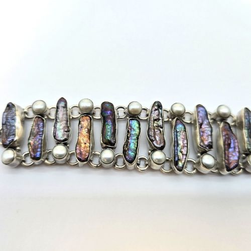 fig 2. A 1960s Japanese silver jewellery set featuring an articulated link bracelet and a matching ring set with elongated, iridescent Biwa pearls and round white pearls.