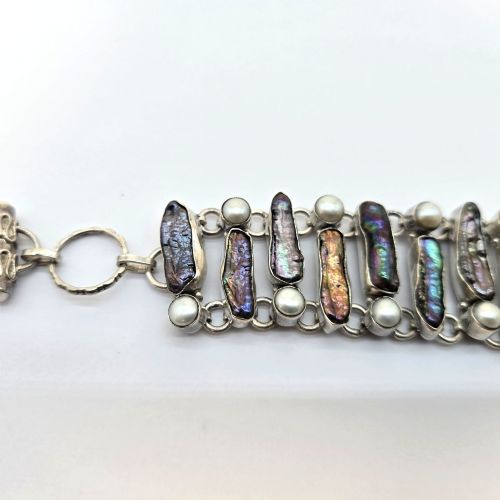 fig 3. A 1960s Japanese silver jewellery set featuring an articulated link bracelet and a matching ring set with elongated, iridescent Biwa pearls and round white pearls.