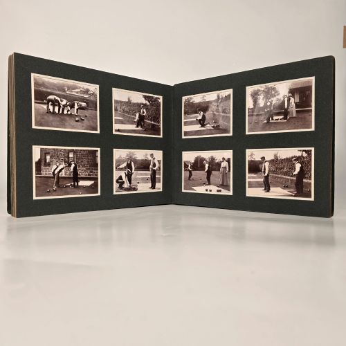 fig 2. A set of three dark green cloth-bound Edwardian photograph albums stacked diagonally, featuring gold-embossed lettering and a geometric motif.