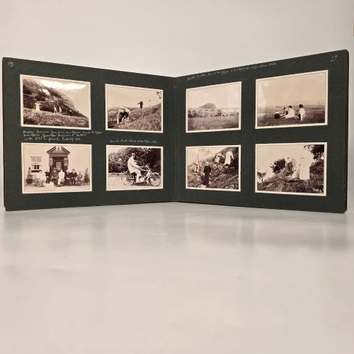 fig 4. A set of three dark green cloth-bound Edwardian photograph albums stacked diagonally, featuring gold-embossed lettering and a geometric motif.