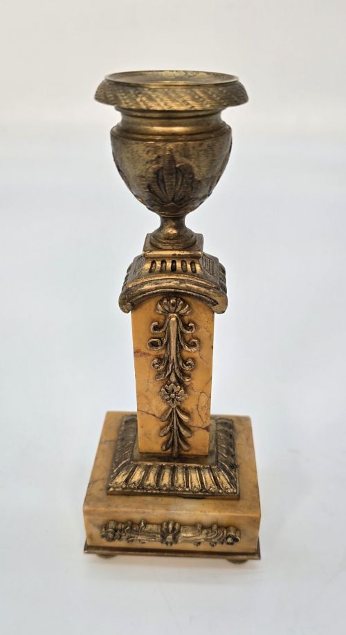 fig 1. A pair of nineteenth-century French Empire gilt-bronze candlesticks featuring urn-shaped nozzles and applied bronze foliage on rectangular yellow marble bases.