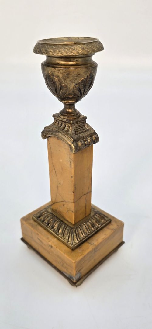 A pair of nineteenth-century French Empire gilt-bronze candlesticks featuring urn-shaped nozzles and applied bronze foliage on rectangular yellow marble bases. View VI
