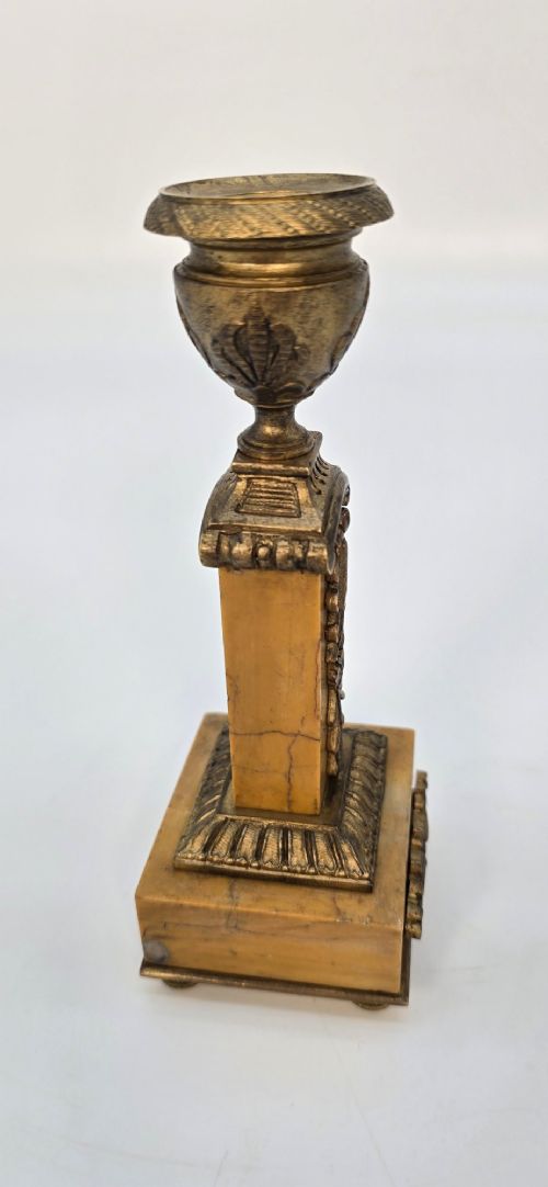 A pair of nineteenth-century French Empire gilt-bronze candlesticks featuring urn-shaped nozzles and applied bronze foliage on rectangular yellow marble bases. View VII