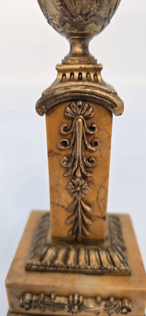 A pair of nineteenth-century French Empire gilt-bronze candlesticks featuring urn-shaped nozzles and applied bronze foliage on rectangular yellow marble bases. View VIII