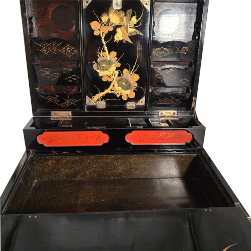fig 6. An open black lacquer writing box decorated with gold floral and bird motifs, revealing internal stationery compartments.