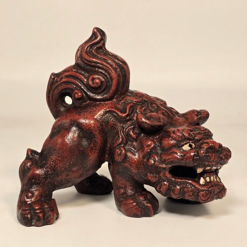 fig 1. A pair of reddish-brown cast iron Chinoiserie guardian lions with swirling manes and open mouths displaying white painted teeth.