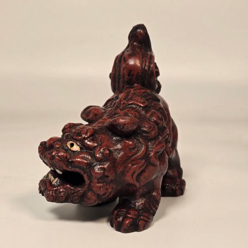 fig 3. A pair of reddish-brown cast iron Chinoiserie guardian lions with swirling manes and open mouths displaying white painted teeth.