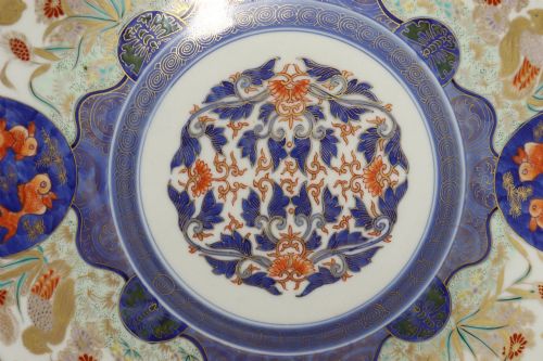 fig 1. A circular antique Japanese porcelain charger plate with hand-painted cobalt blue, iron red, and gilded decoration featuring birds, goldfish, and floral patterns.