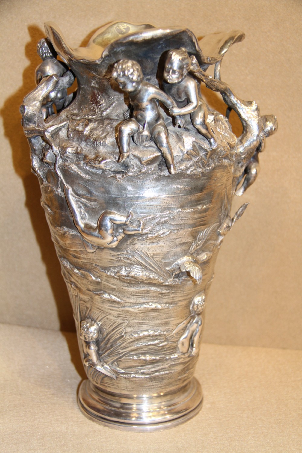 A large and decorative silver plated vase embellished with water nymphs  casting their nets into a lake. View II