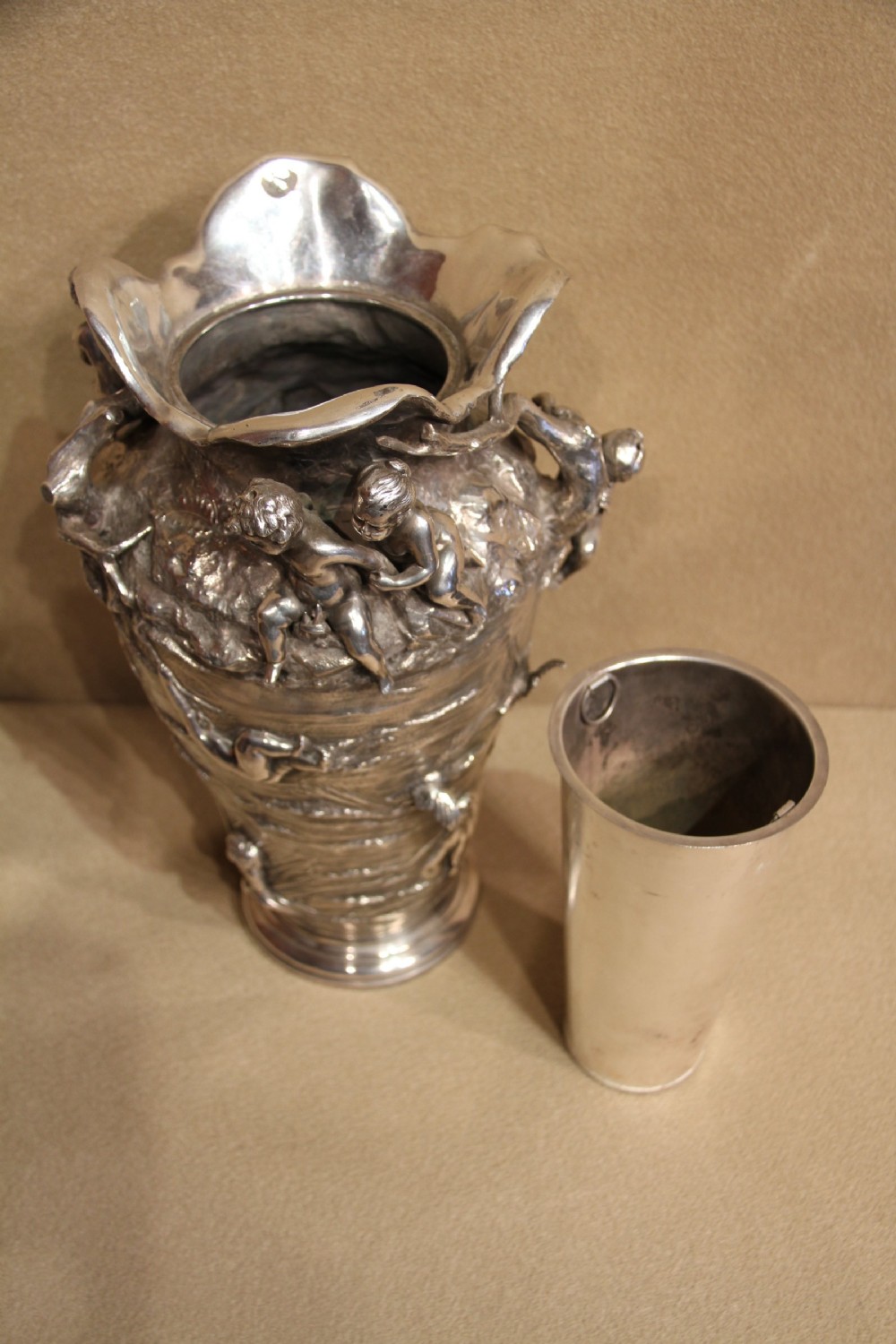 A large and decorative silver plated vase embellished with water nymphs  casting their nets into a lake. View V