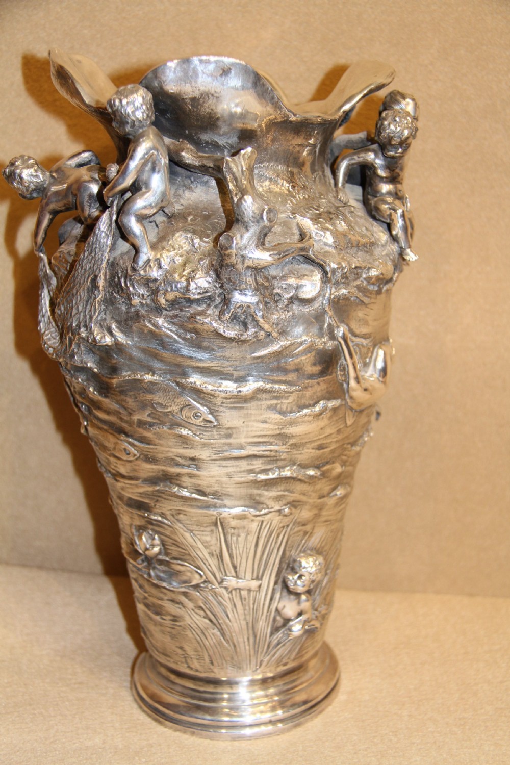 A large and decorative silver plated vase embellished with water nymphs  casting their nets into a lake. View VI