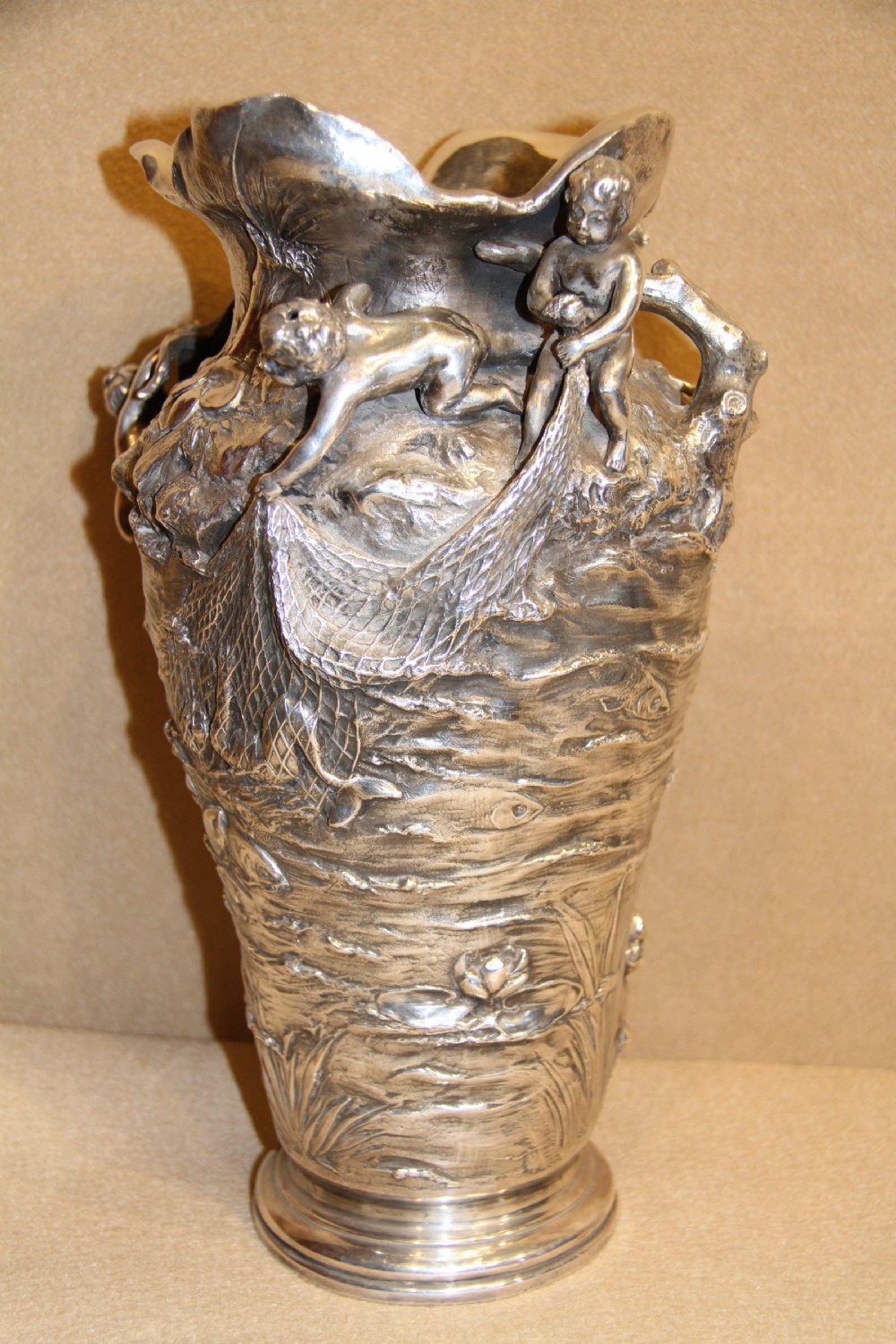 A large and decorative silver plated vase embellished with water nymphs  casting their nets into a lake. View VIII