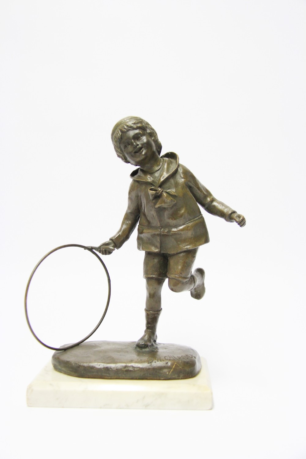 A delightful bronze study of a young boy playing with a hoop and stick