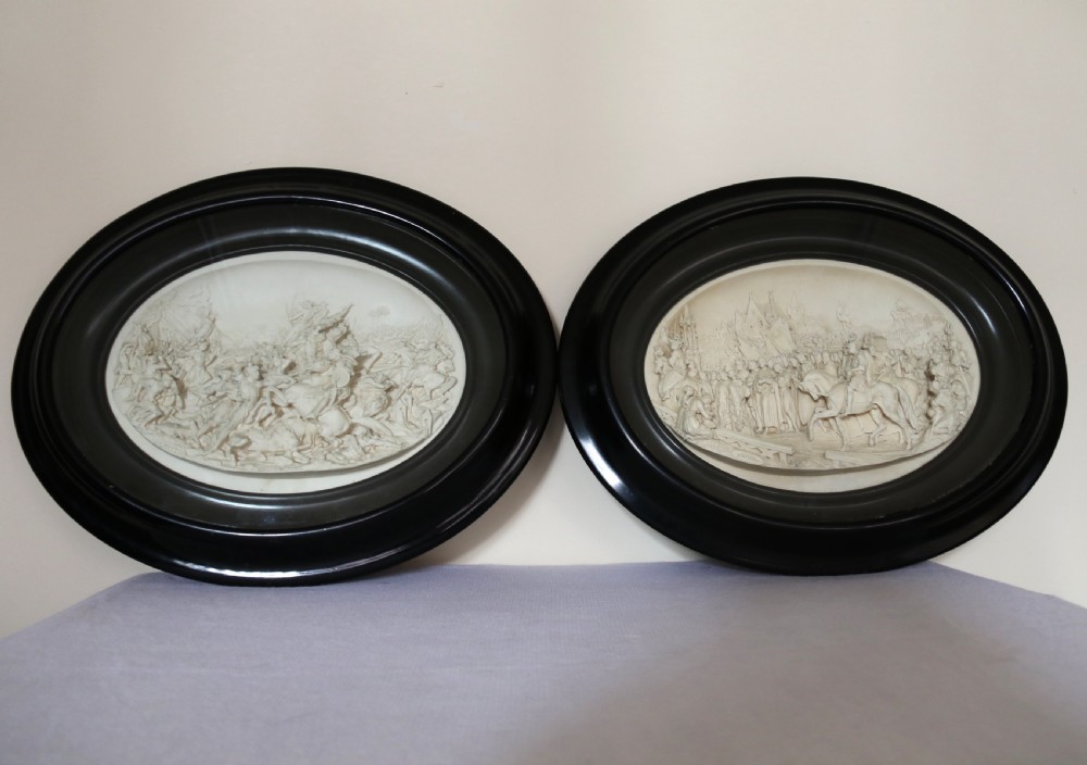 A pair of French oval plaques cast in plaster