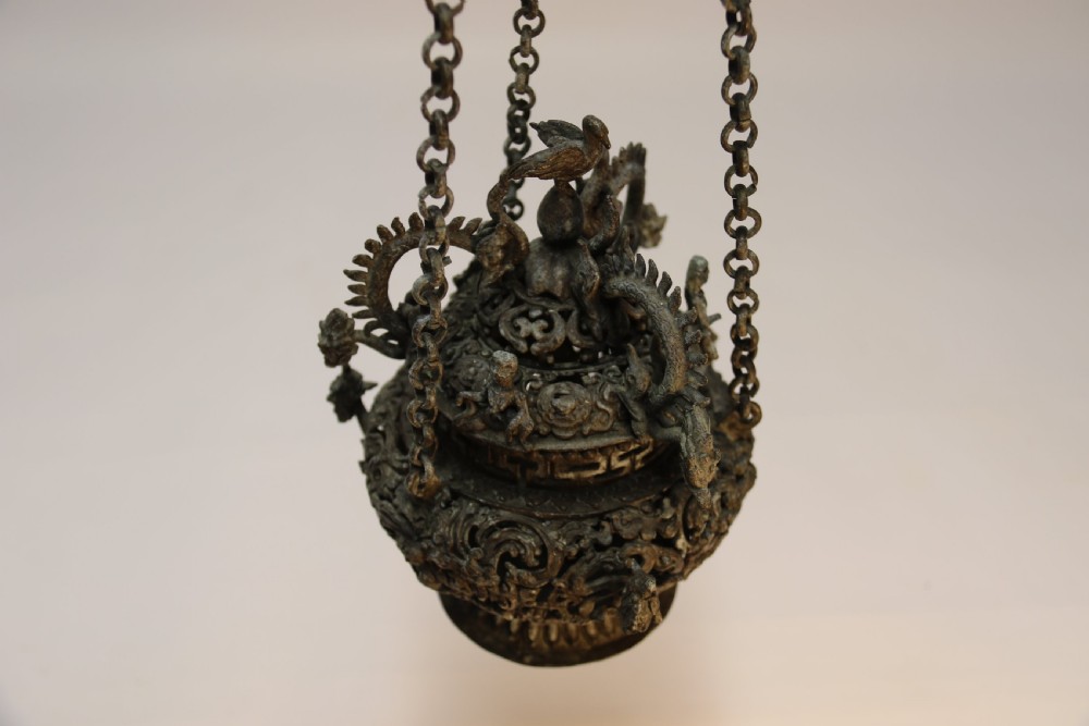 A dark patinated bronze hanging incense burner featuring dragon openwork motifs and a bird finial suspended by three link chains. View VIII