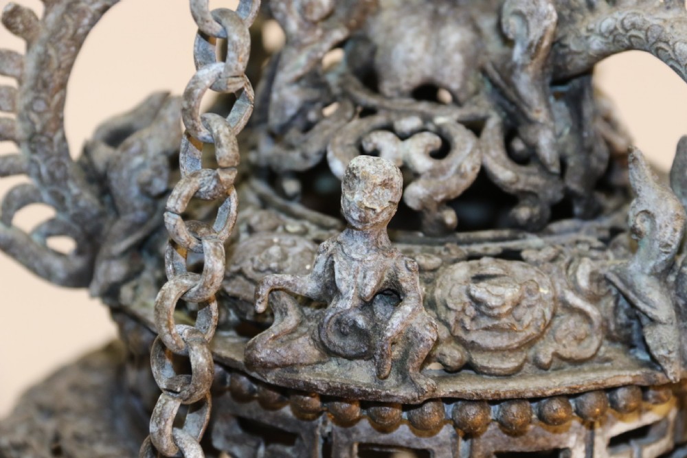 A dark patinated bronze hanging incense burner featuring dragon openwork motifs and a bird finial suspended by three link chains. View IX