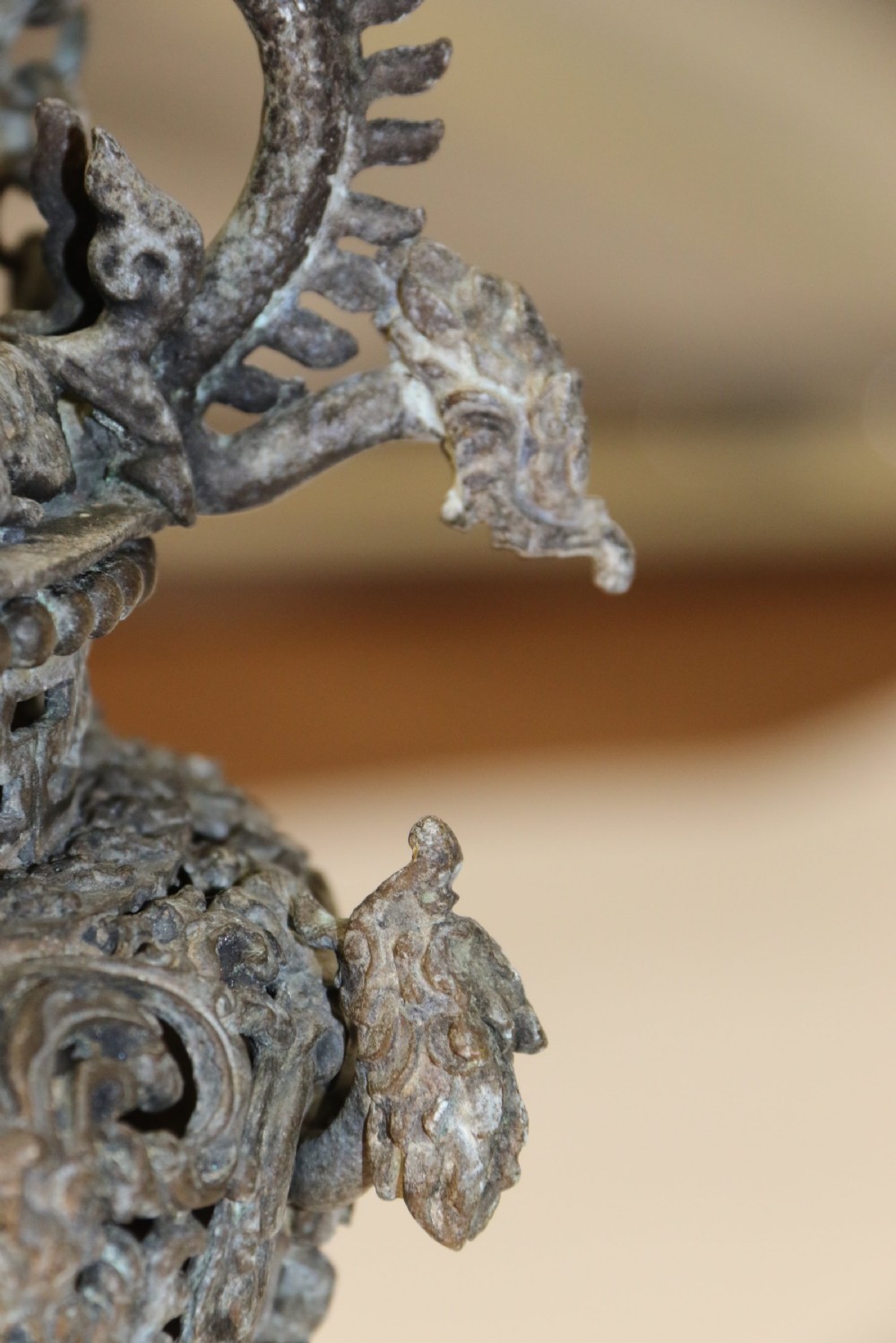 A dark patinated bronze hanging incense burner featuring dragon openwork motifs and a bird finial suspended by three link chains. View X