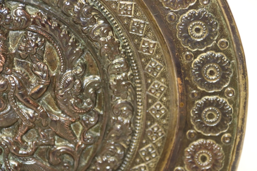 A circular 19th-century Indian bronze plaque featuring intricate chased floral borders and a central high-relief Hindu deity figure. View VIII