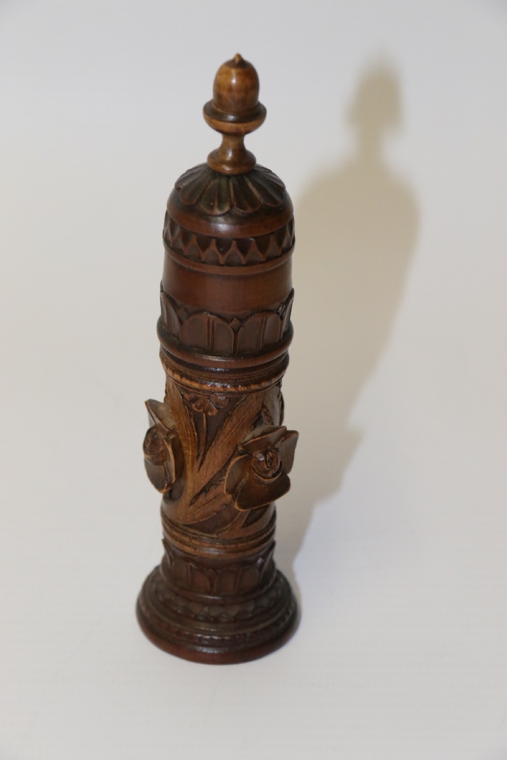 Two hand-carved fruitwood sewing cases featuring cylindrical shapes, leaf relief patterns, and turned finials. View IV