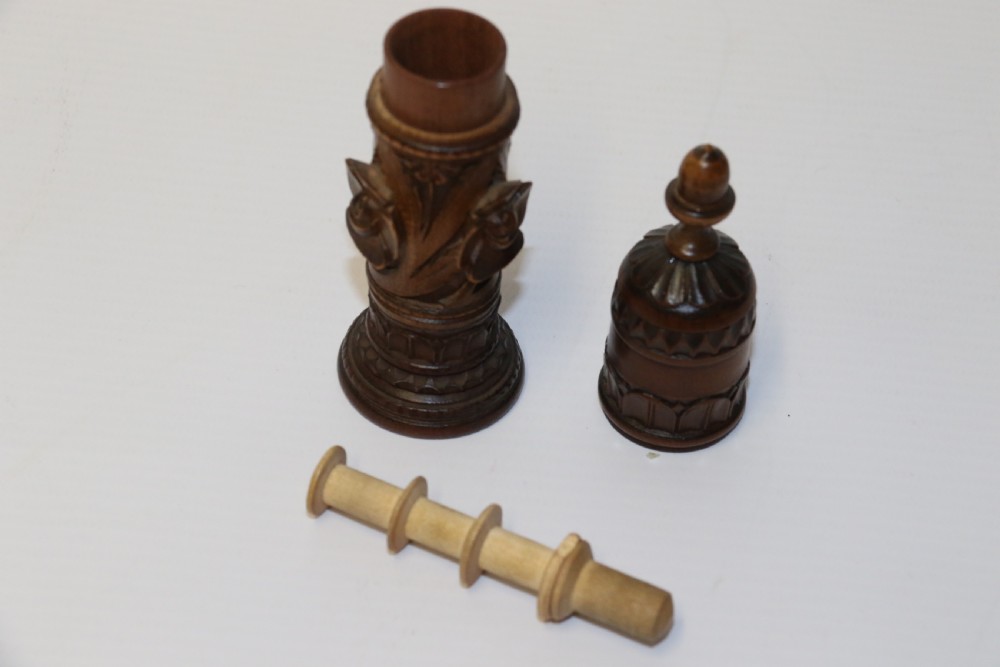 Two hand-carved fruitwood sewing cases featuring cylindrical shapes, leaf relief patterns, and turned finials. View XII