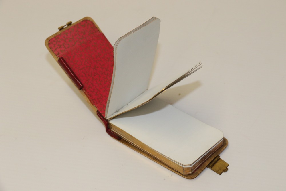 An antique Victorian Mauchline ware wooden pocket notebook displaying a black oval transfer print depicting the Arcades at Crystal Palace, featuring an ornate brass top clasp. View VIII