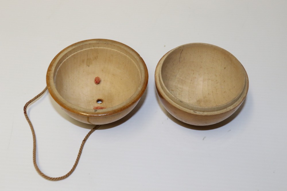 A spherical turned wooden Mauchline ware string holder featuring a black transfer print of Hastings Pier and a hanging cord. View VII