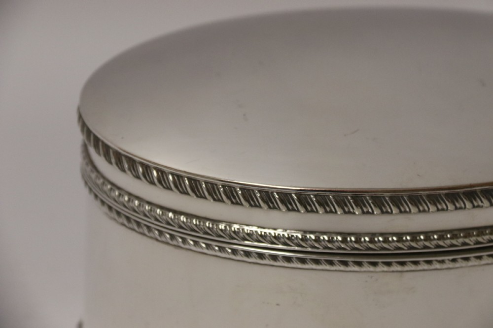 A polished silver-plated oval box featuring a smooth domed lid and rope-twist borders around the rim and base. View II