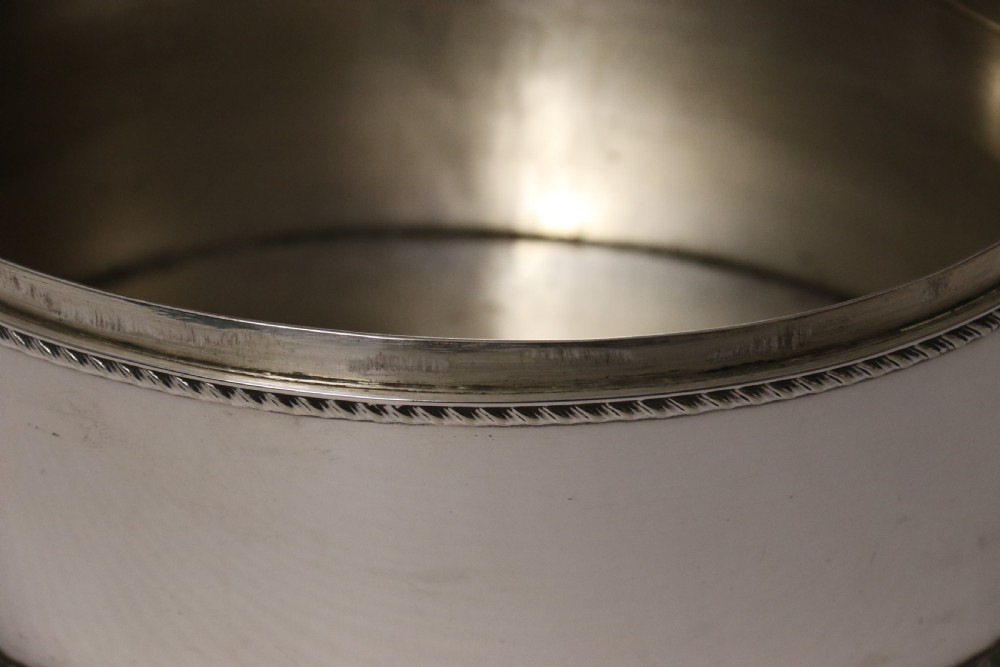 A polished silver-plated oval box featuring a smooth domed lid and rope-twist borders around the rim and base. View X