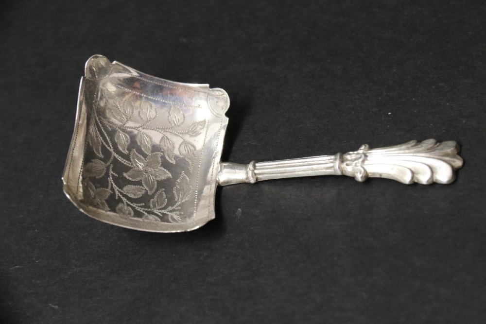 An antique Victorian silver caddy spoon featuring a rectangular bowl with bright-cut floral and leaf engraving and a decorative short handle. View III
