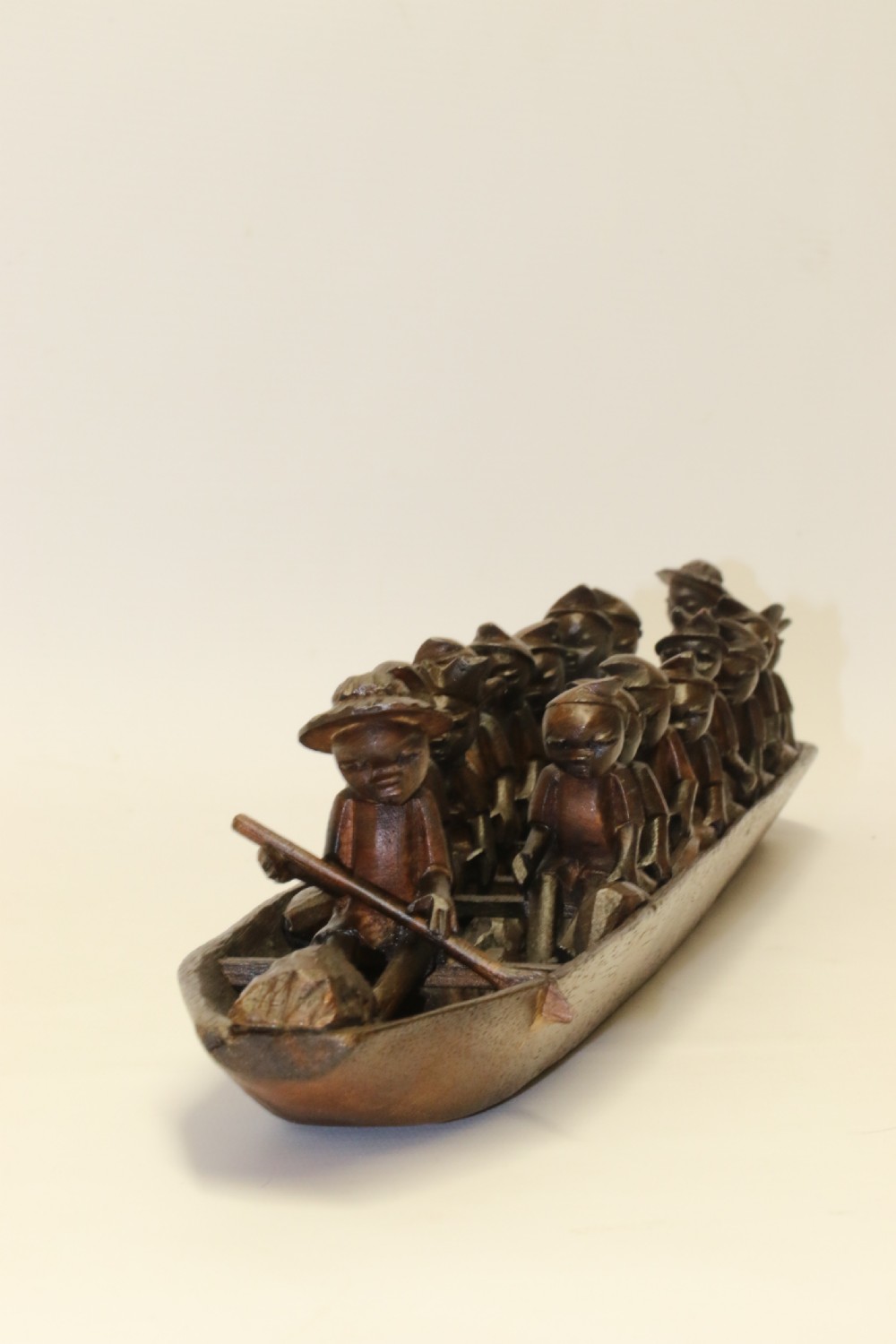 An African Carved Wooden model of a dug-out canoe with 18 seated tribal figures. View III
