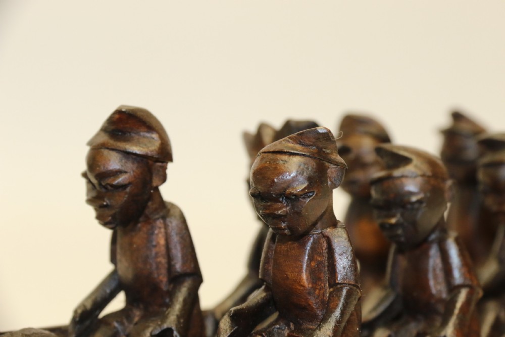 An African Carved Wooden model of a dug-out canoe with 18 seated tribal figures. View V