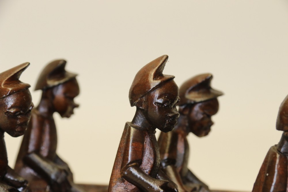 An African Carved Wooden model of a dug-out canoe with 18 seated tribal figures. View IX