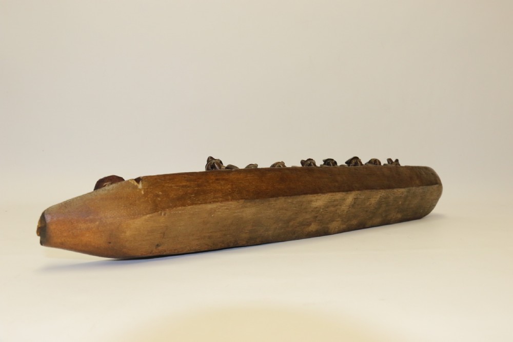 An African Carved Wooden model of a dug-out canoe with 18 seated tribal figures. View XI